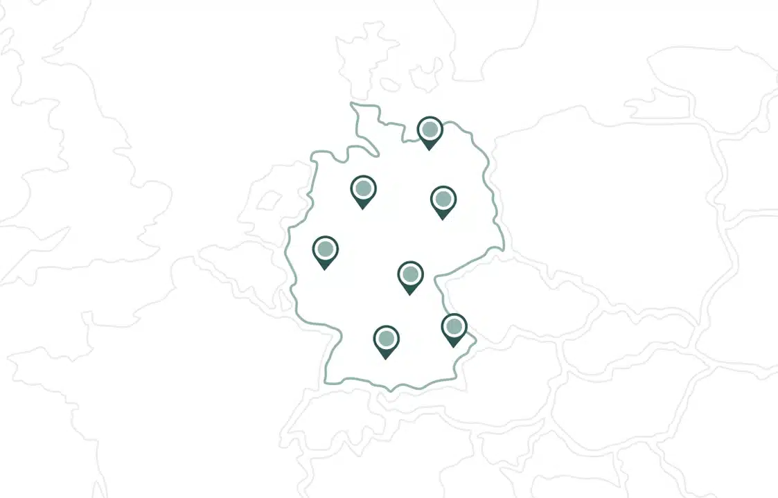 &Uuml;bersichtskarte Von Deutschland Mit Sieben Stecknadeln, Die Verschiedene Orte Innerhalb Des Landes Markieren; Die Umliegenden L&auml;nder Sind Nur Schwach Sichtbar.
