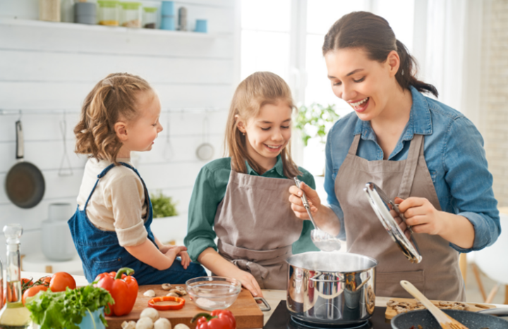 Familie kocht zusammen in der Küche, frisches Gemüse auf dem Tisch, lächelnd, reinigung.