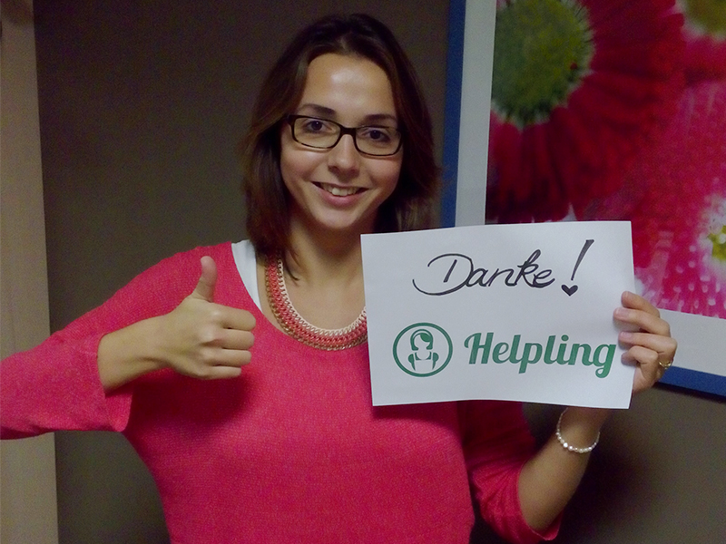 Frau hält "Danke!"-Schild mit Helpling-Logo, zeigt Daumen hoch; Thema Reinigung.