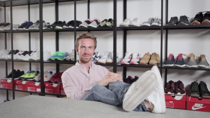 Mann entspannt vor Schuhregalen; sportliche Sneaker, keine Putzfrau oder reinigung sichtbar.