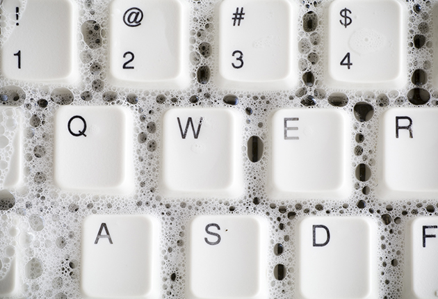 Seifenblasen auf weißer Tastatur, Reinigungskraft putzt Tasten.