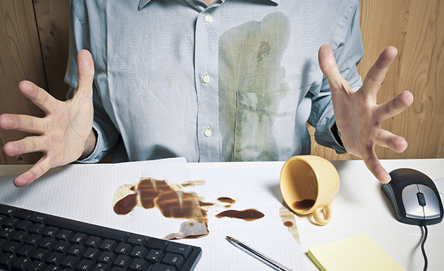 Verschütteter Kaffee auf Hemd und Schreibtisch; Reinigung durch Putzfrau nötig.