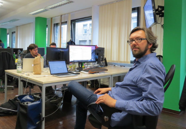 Männer arbeiten in einem Büro mit Computern; keine Putzfrau oder reinigungskraft sichtbar.