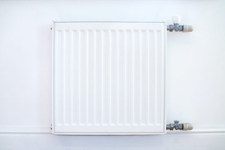 Weißer Heizkörper an weißer Wand, ideal zum Putzen für eine gründliche Reinigung.