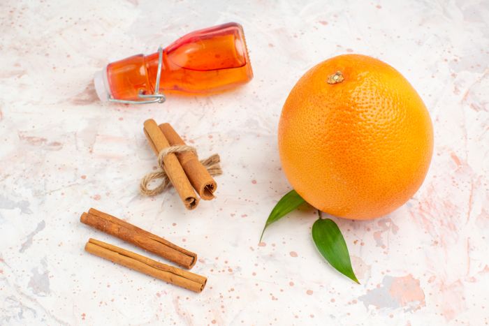 Front View Fresh Orange Cinnamon Sticks Bottle Bright Background