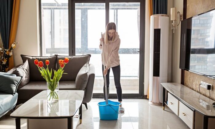 Frau Beim Putzen Mit Wischmopp Und Eimer Im Wohnzimmer, Tulpen Auf Dem Tisch.