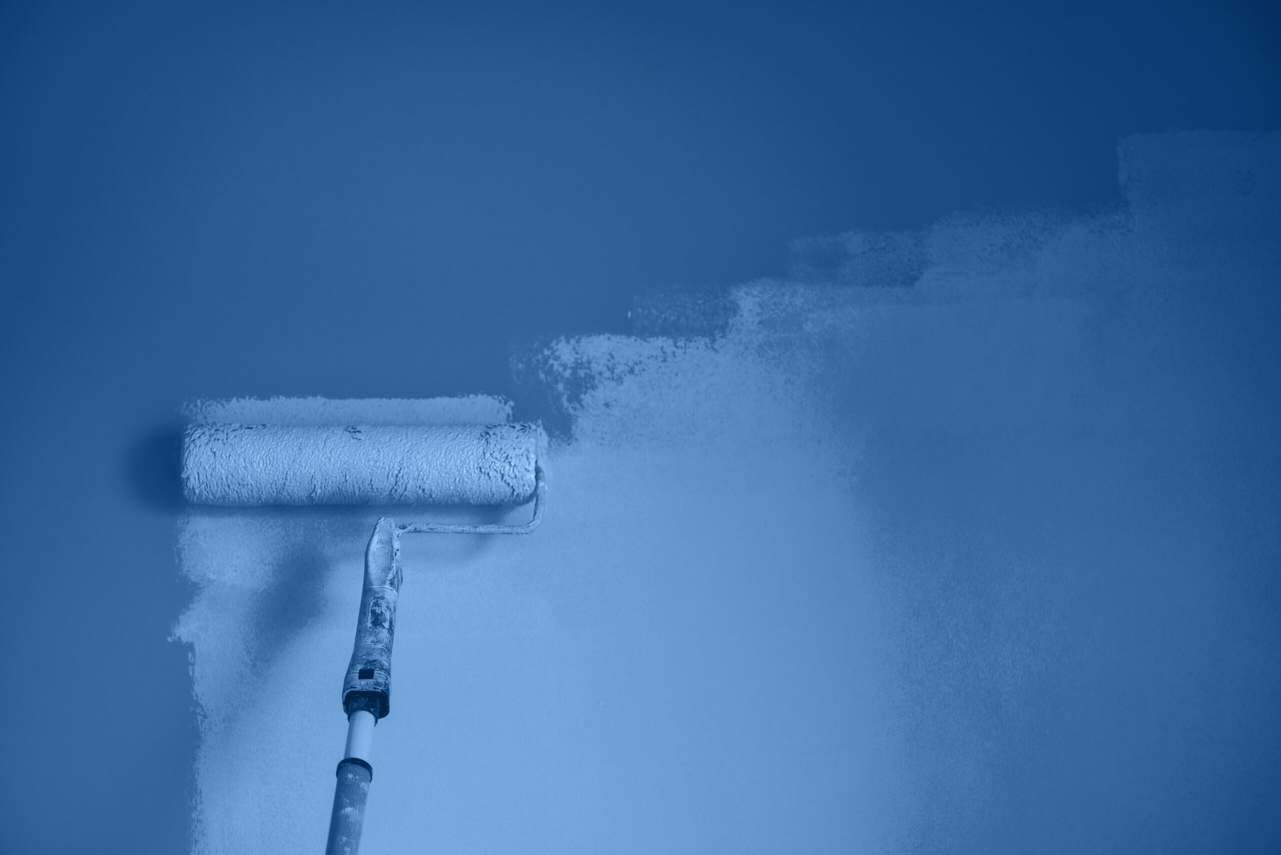Farbrolle streicht blaue Wand. Reinigungskraft könnte nach dem Malen putzen.