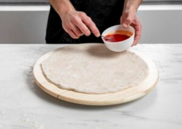 High Angle Man Spreading Tomato Sauce Pizza Dough 300X213 1