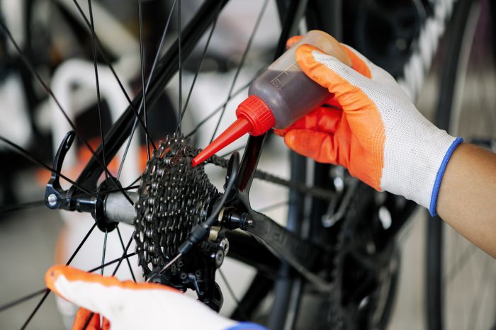Close Up Male Mechanic Working Bicycle Repair Shop Mechanic Repairing Bike Using Special Tool Wearing Protective Gloves Bike Maintenance Concept