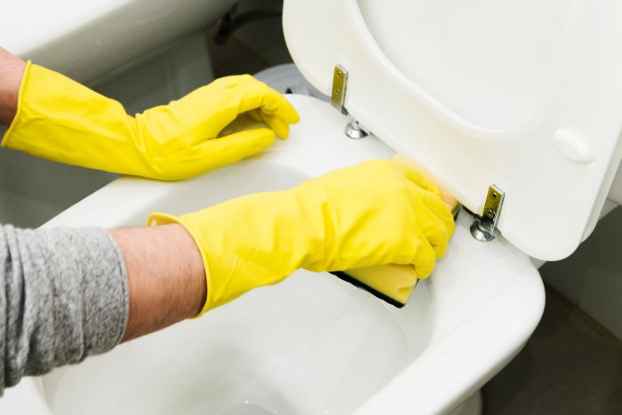 Close Up Man Cleaning Toilet With Sponge 1