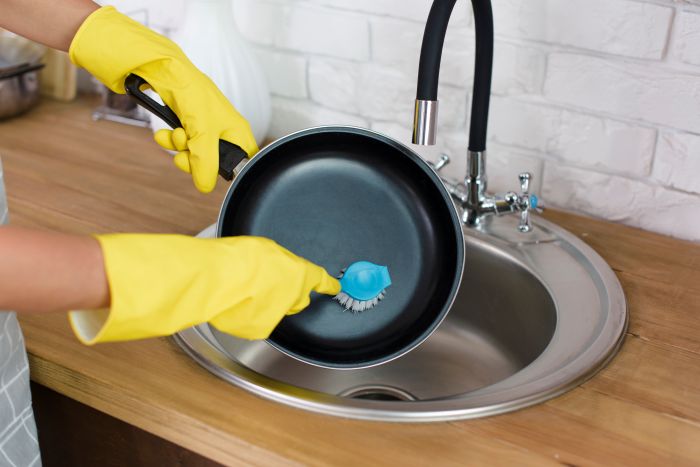 Person Hand With Yellow Glove Washing Pan With Brush Kitchen