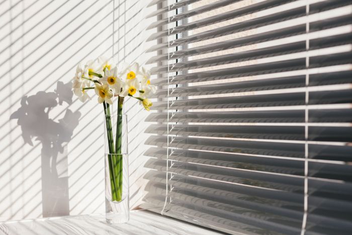 Vase Mit Weißen Blumen Auf Fensterbank, Sonnenlicht Und Jalousien. Reinigen Der Fenster Empfohlen.