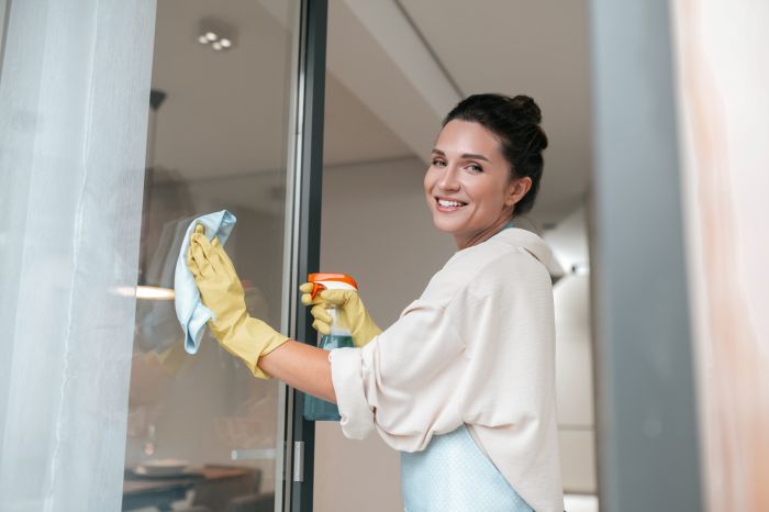 Woman Apron Cleaning Windows Looking Involved