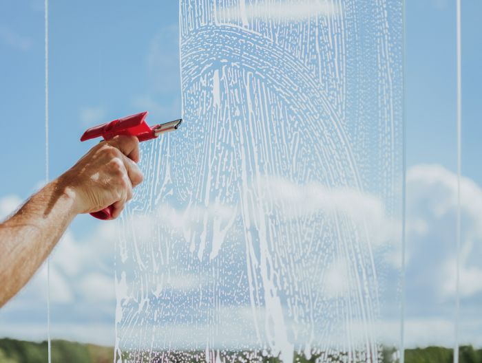 Mans Hand Cleans Windows Balcony With Detergents Tools Against Sky Trees