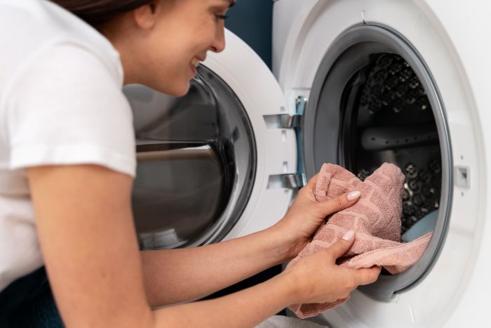 Woman Taking Clothes From Washing Machine