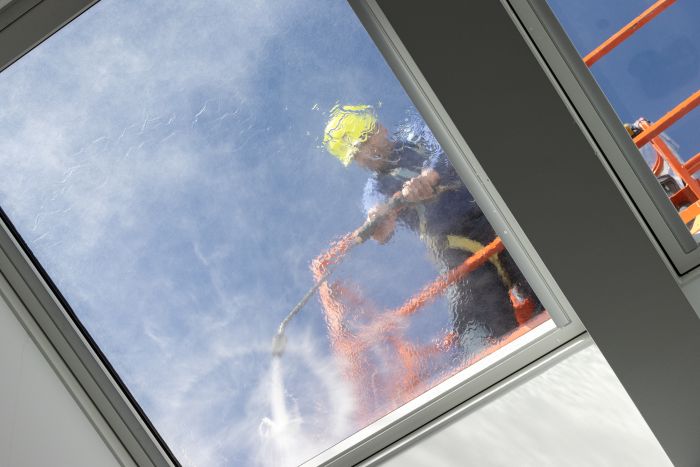Worker Cherry Picker Cleaning Roof Windows With High Pressure Water Jet Low Angle Shot