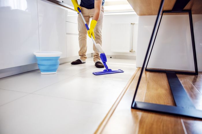 Young Worthy Man Cleaning Kitchen Floor Trying Out New Cleaning Product 1