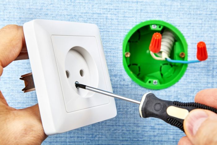 Cropped Hands Fixing Electrical Outlet