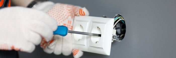Repairman Gloves Fixing Socket With Screwdriver