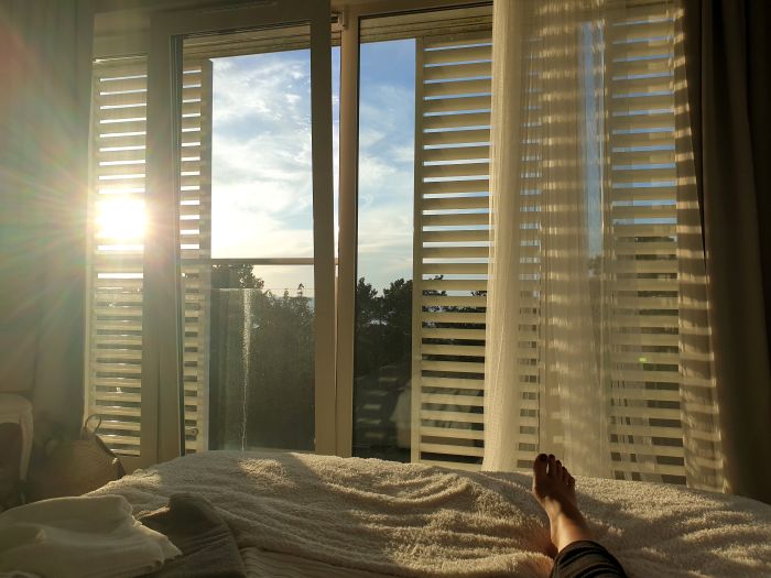 Low Section Woman Relaxing Bed Against Window