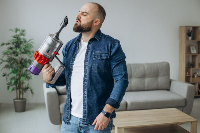 Man Doing House Work With Accumulator Vacuum Cleaner