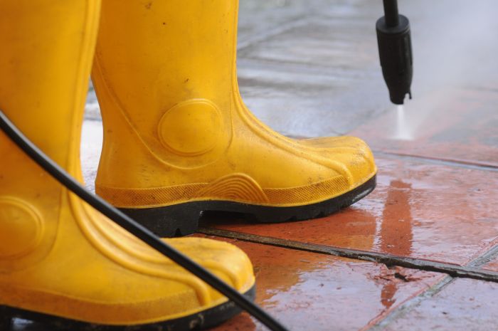 Person Wearing Yellow Rubber Boots With High Pressure Water Nozzle Cleaning Dirt Tiles 4