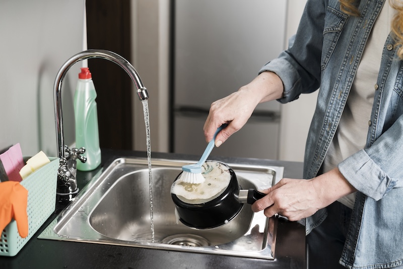Woman Cleaning Pot Sink With Brush
