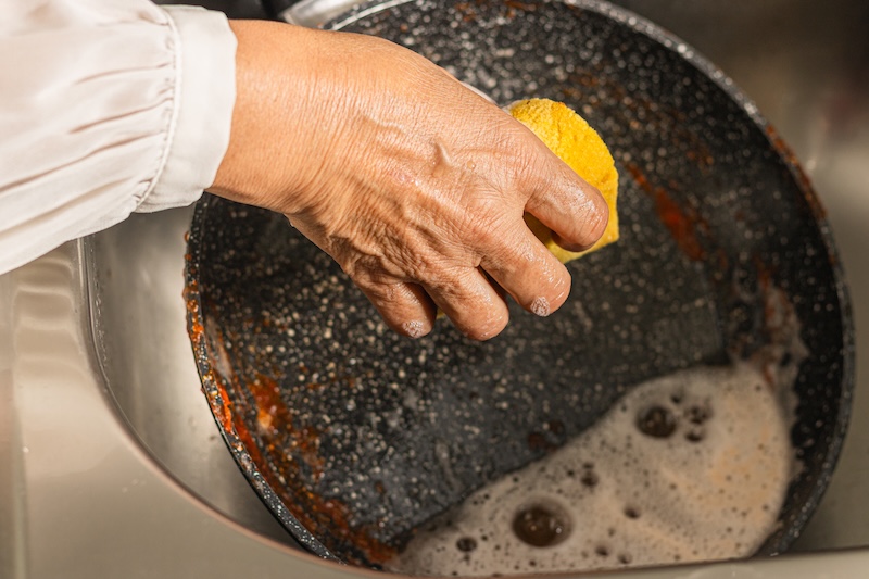 Woman Washing Dirty Frying Pan With Sauce Sink Top View
