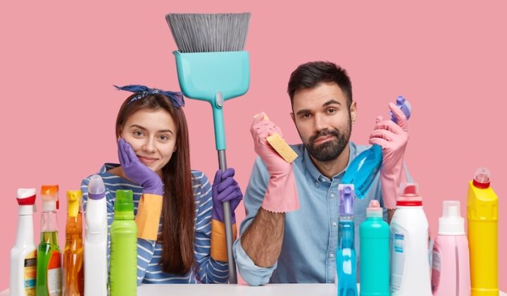 Ein Mann und eine Frau halten Reinigungsmittel in den Händen und lächeln freundlich.