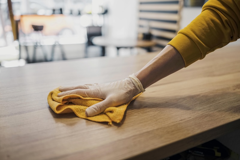 Side View Barista Cleaning Table While Wearing Latex Glove
