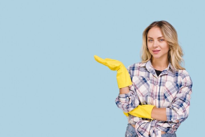 Eine Frau Mit Gelben Handschuhen Hält Einen Reinigungshandschuh In Der Hand.