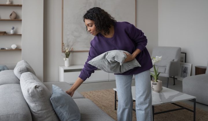 woman arranging pillows in her living room