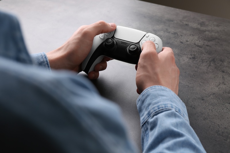 Man Using Wireless Game Controller Grey Table Closeup