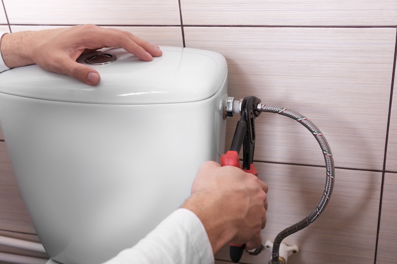 Plumber Fixing Water Hose Toilet Cistern Closeup